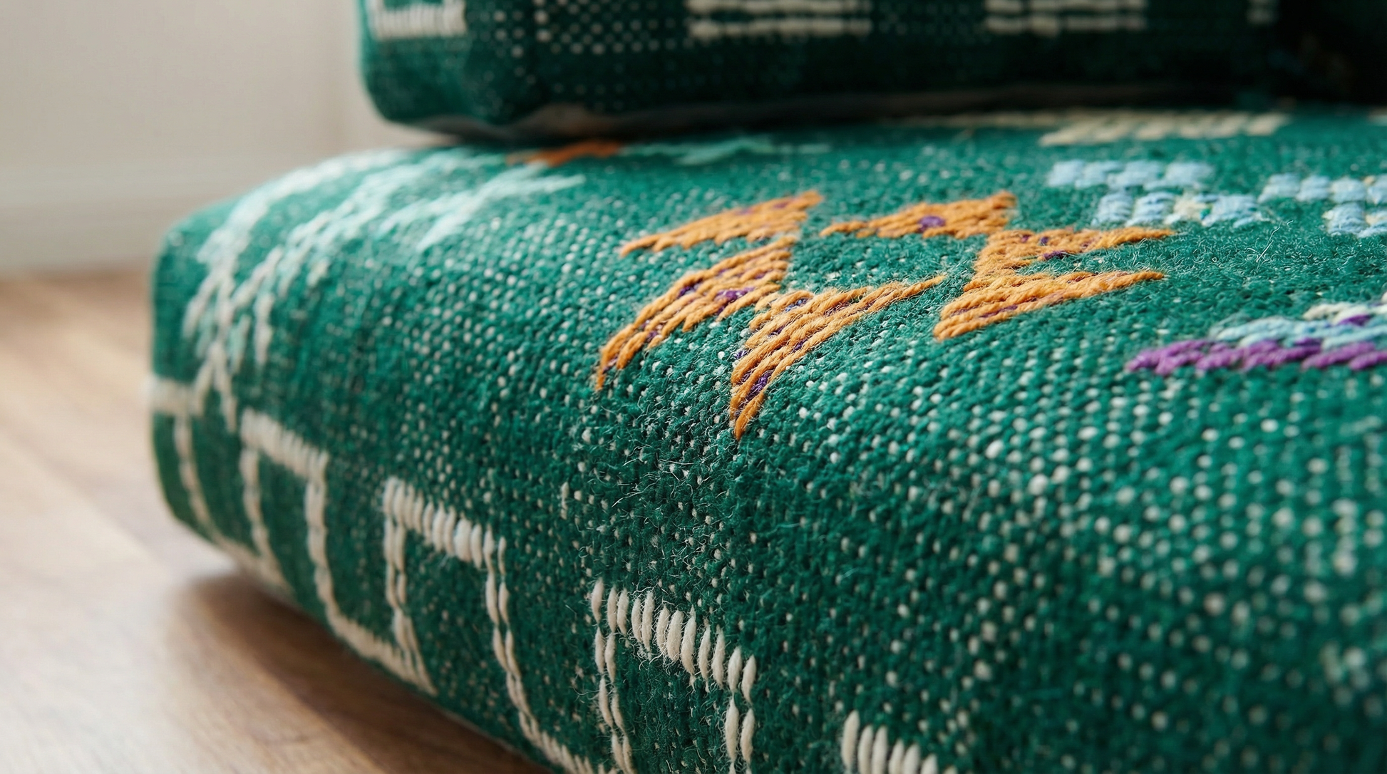 Green fabric with white patterns and orange text on a wooden surface